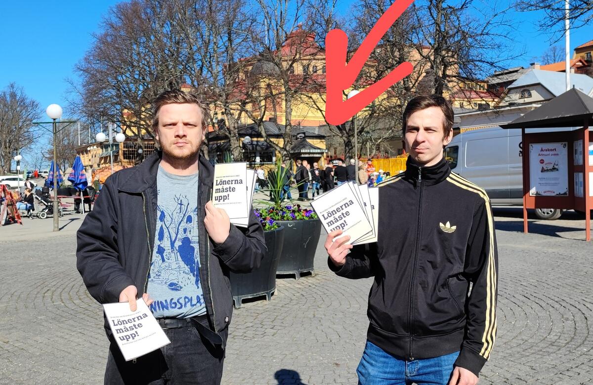 Aktivister håller upp flygbladet "Lönerna måste upp!" framför en delegation av LO-pampar
