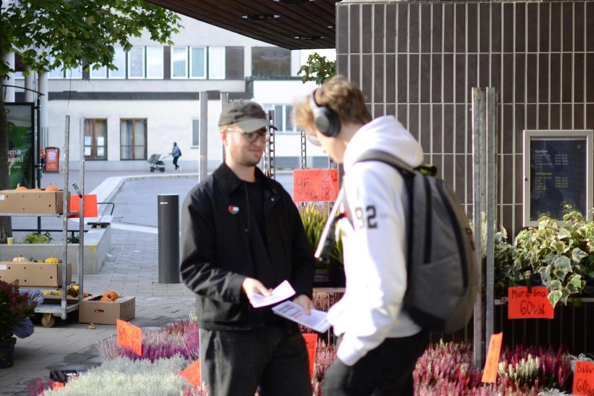 Medlem står och delar ut flygblad