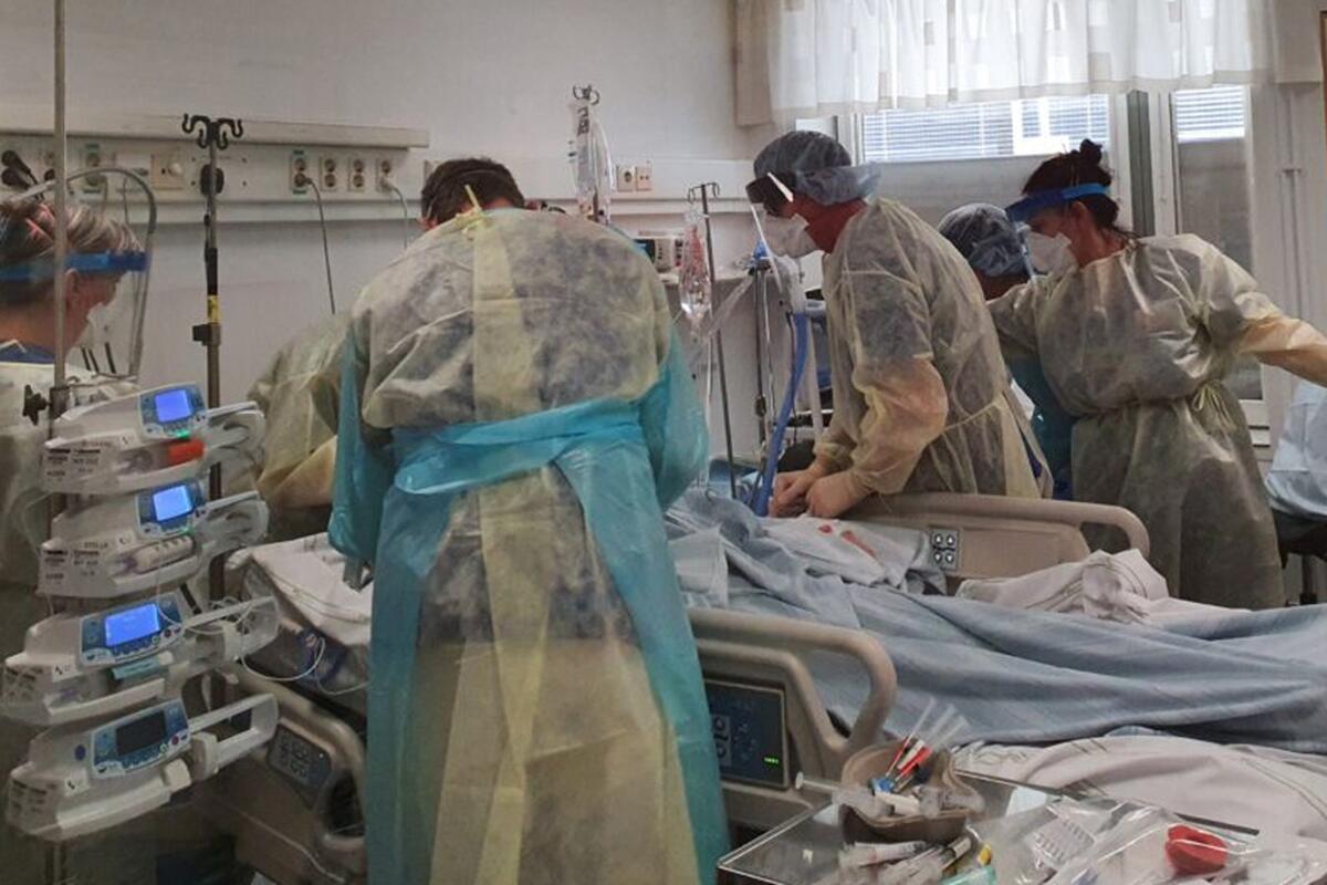Läkare i full mundering samlas kring en patient.