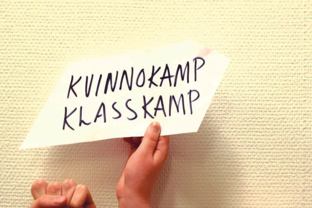 Hand som håller lapp där det står kvinnokamp klasskamp